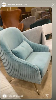 a blue chair sitting on top of a wooden floor next to a brown chair and tan chair