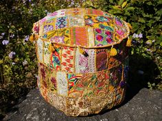 a patchwork basket sitting on top of a rock