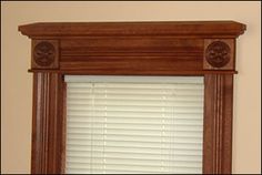 a window with wooden trim and white blinds