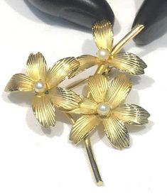 This very pretty vintage brooch satin gold tone textured flower petals with faux pearls (could very well be cultured)  The brooch measures 2" x 1.75" with a roll over clasp and is in very good vintage condition with the satin gold tone finish nice.  Unsigned and weighs 7 grams  Shipping prices vary on the weight of item. I do my best to keep shipping costs reasonable. The prices quoted are not trackable and is the least expensive airmail postage for most countries. If you want tracking, the cost Vintage Gold Pearl Brooches, Vintage Flower-shaped Pearl Jewelry, Victorian Gold Flower Brooch, Vintage Yellow Gold Flower Brooches, Vintage Gold Flower Shaped Brooch, Vintage Texture, Flower Petals, Vintage Brooches, Faux Pearl