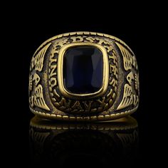 The Gold United States Military Blue Stone Navy Ring from our Military Collection is custom molded and cast with a premium blend of surgical stainless steel with 18K PVD coated gold that offers enhanced durability, even after exhaustive wear. The Blue Stone Navy Ring features a deep blue ocean-inspired stone centerpiece with a detailed eagle sigil on both sides of the ring. This ring is a bulkier-styled ring that is great for men who want a classic everyday ring or a veteran who wants a memorabl Navy Blue And Gold Rings, Classic Blue Stainless Steel Jewelry, Luxury Blue Classic Signet Ring, Blue Brass Ring Jewelry, Luxury Blue Antique Signet Ring, Us Navy Rings, Bike Chain Bracelet, Navy Rings, Navy Military Cap