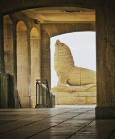 a stone lion statue sitting on top of a wooden floor next to an open doorway