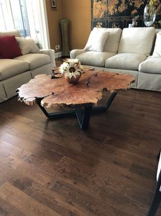 a living room filled with furniture and a wooden table on top of a hard wood floor