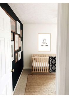 a baby's room with a crib and pictures on the wall above it