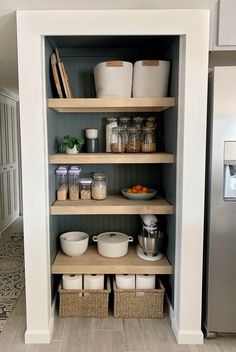 an organized pantry with baskets and containers on the bottom shelf, along with other kitchen items