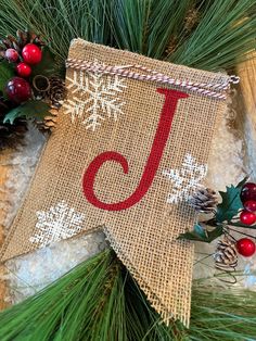 a burlap christmas star decoration with the letter j on it and pine cones