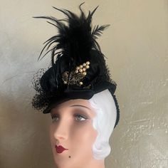 This Is An Adorable Black Felt Tilt Hat From The 1930s'. The Medium Height Crown Is In A Tubular Shape, And The Short Brim Surrounding It, Ends In A Point At The Back. Black Veiling Adorns The Crown, And There Is A Satin Bow At One Side, From Which A Spray Of Black Feathers Emerge. There Is Also A Magnificent Bronze Metal Jewel With Pearls, Which Is Beautifully Preserved For Its Age. There Is Also A Grosgrain Covered Wide Elastic Attached, So As To Hold The Hat In A Tilted Position. Tilt Hats We Vintage Short Brim Mini Hat For Costume, Classic Fitted Costume Hats And Headpieces For Party, Fitted Top Hat With Short Brim For Costume Party, Vintage Mini Hats For Costume Party, Vintage Headpieces For Costume Party, Fitted Top Hat For Kentucky Derby Costume, Vintage Fitted Headpieces For Party, Black Gatsby Style Fascinator For Evening, Black Gatsby Fascinator For Evening