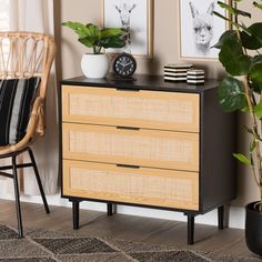 a wooden dresser sitting next to a chair and potted plant