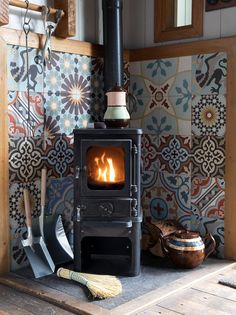 a wood burning stove sitting inside of a kitchen next to a wall covered in tiles