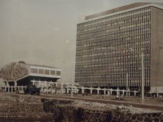 an old black and white photo of a large building next to a body of water