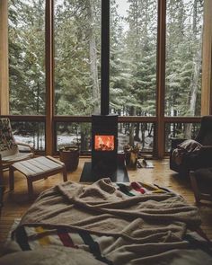 a living room filled with furniture and a fire place next to a large glass window