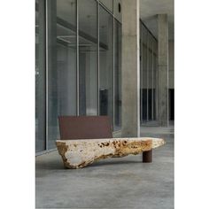 a bench sitting in the middle of an empty room with glass walls and floor to ceiling windows