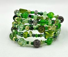 This gorgeous green wrap bracelet is made on silver memory wire with an assortment of glass beads, glass pearls, Swarovski crystals, and large crystal disco ball accent beads and will wrap around your wrist 4 times.  You will look gorgeous in green with this accent piece! ★ Return to my main shop page here for more inventory ★ www.etsy.com/shop/bridgetollbeading ★ Read my FAQ's below and if you have any further questions please do not hesitate to contact me! ★ https://www.etsy.com/shop/BridgeTollBeading?ref=hdr#more-section Green Beaded Stretch Bracelet For Party, Green Stretch Bracelet With Round Beads For Party, Green Round Beads Stretch Bracelet For Party, Green Crystal Bead Party Bracelet, Green Wire Wrapped Bracelets With Round Beads, Unique Green Beaded Bangle Bracelet, Green Beaded Bangle Crystal Bracelet, Green Wire Wrapped Bracelets, Green Multi-strand Beaded Bracelets Gift