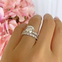 a close up of a person's hand with a diamond ring