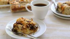 there is a piece of cake on the plate next to a fork and cup of coffee