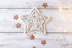 a crocheted star ornament sitting on top of a white wooden table