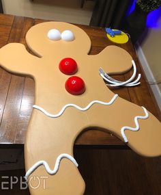 a gingerbread man made out of cardboard sitting on top of a wooden table