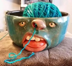 a bowl with yarn in the shape of a face