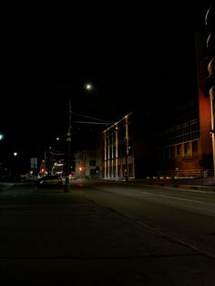 an empty city street at night with traffic lights