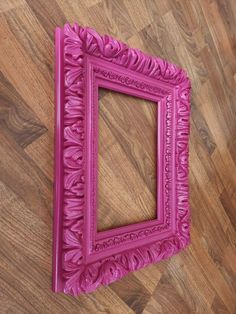 a pink frame sitting on top of a wooden floor