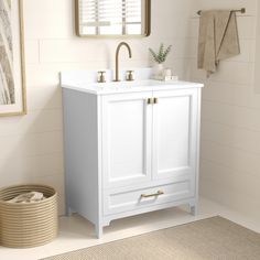 a white bathroom vanity with gold faucet, mirror and towel rack on the wall