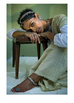 a woman sitting on top of a wooden chair