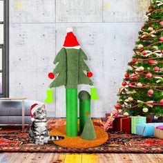 a cat sitting in front of a christmas tree on the floor next to a stuffed animal