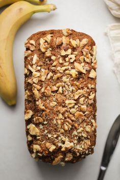 a loaf of banana nut bread next to two bananas