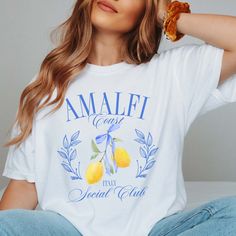 Transport yourself to the sun-drenched shores of Italy with our Amalfi Coast Social Club Comfort Color Tee, designed for those who yearn for the laid-back elegance of coastal living. Made from premium materials, this tee ensures both comfort and durability, providing a cozy fit for all your adventures. The design features a chic and minimalist emblem of the Amalfi Coast Social Club, evoking the allure of this iconic destination. Whether you're strolling along the beach or enjoying a leisurely br Halloween Crop Top, Halloween Skirt, Ron Jon, Letter Print Tee, Oversized Graphic Tee, Lemon Print, Comfort Color, Fabric Texture, Social Club