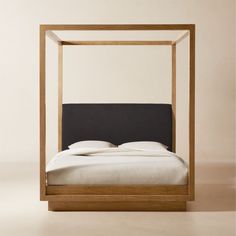 a bed with a black headboard and white sheets