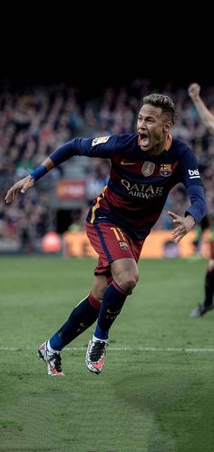 a soccer player is running on the field with his mouth open and one foot in the air