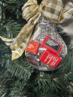 an ornament hanging from a christmas tree decorated with red and gold ornaments,