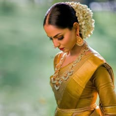 a woman in a yellow sari with pearls on her head