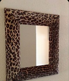 an animal print mirror mounted on the wall above a light fixture with text overlay reading, insolent indulgencies