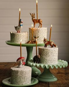 there are many small cakes with candles on the cake platter and one is decorated with figurines