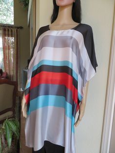 Brighten up your summer with this silky tunic.  You can wear it as a dress or a top over pants, leggings or jeans.  Also makes a great summer coverup for those days at the pool or beach., One size.  Fits small to medium sizes.  The width is 35 inches, edge to edge, 70 inches around the body.  The side seams are 5 inches from the edge, giving  50 inches for body room.  The length is 36 inches.  The fabric is 20% silk and 80% polyester.  The neckline is hand finished.  Hand wash.  Hang to dry. Multicolor Silk Printed Tunic, Multicolor Silk Tunic For Spring, Spring Multicolor Silk Tunic, Spring Vacation Silk Tunic, Silk Tunic For Spring Vacation, Multicolor Silk Dress For Beach Cover-up, Flowy Multicolor Summer Tunic, Silk Tunic For Spring Beach Days, Multicolor Silk Summer Tunic