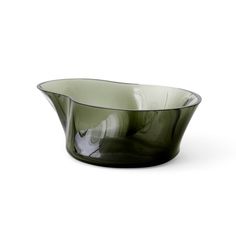 a green glass bowl sitting on top of a white table