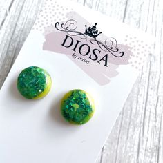 Green and Yellow Shiny Round Button Shaped Stud Earrings These eye-catching, round shiny studs are handmade and so easy to pair with any outfit. Fresh and vibrant colours that will complement your style. The resin and custom glitter combination are carefully mixed and hand-poured, then cured with a stunning, shiny domed finish. Every pair is unique and slightly different due to the nature of resin. Note that your pair of studs may be slightly different to those in the photographs.  1.6 cm diameter Green Round Clip-on Earrings For Gift, Green Round Clip-on Earrings As Gift, Green Round Plug Earrings Gift, Green Round Plug Earrings As Gift, Handmade Green Round Clip-on Earrings, Green Circle, Custom Glitter, Round Button, Earrings Green