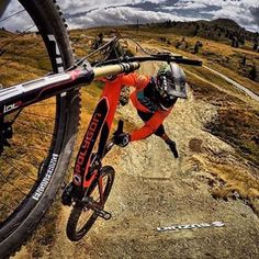 a man riding a bike down a dirt road