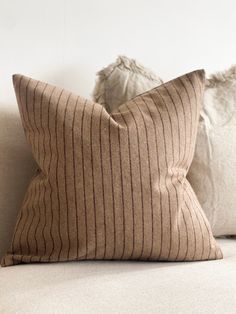 two pillows sitting on top of a couch next to each other