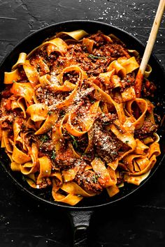 a skillet filled with pasta and meat sauce