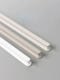 three white plastic dowels on a gray surface