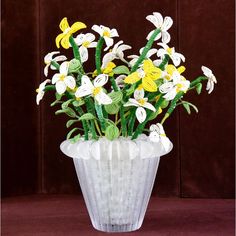 a vase filled with yellow and white flowers