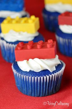 lego cupcakes with white frosting and blue icing on red tablecloth