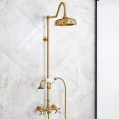 a bathroom with a gold shower head and faucet