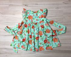 "Beautiful handmade baby girl, toddler, Girl dress is a Retro style , flutter sleeve, custom dress made from a Bright floral cotton fabric. The dress buttons in the back, it also ties in the back. All seams are finished. Sewn with great care. Boutique quality sewing. I have a size 4 ready to ship. If you need the length of the dress to be different please include a message with order. Measurements of the dress. size , length, 3 months length 12.5\". 6 months, length 14.5\". Size, Chest, Waist, L Playful Floral Print Dress With Flutter Sleeves, Playful Floral Print Dress With Ruffle Sleeves, Playful Ruffle Sleeve Dress With Floral Print, Spring Floral Print Twirl Dress With Flutter Sleeves, Spring Twirl Dress With Floral Print And Flutter Sleeves, Spring Floral Twirl Dress With Flutter Sleeves, Flowy Spring Twirl Dress With Flutter Sleeves, Green Ruffle Dress With Butterfly Sleeves, Green Ruffled Dress With Butterfly Sleeves