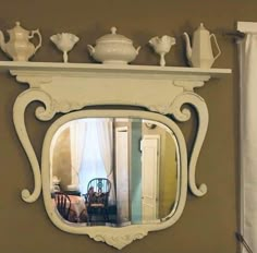 a mirror that is on the side of a wall next to a table and chair