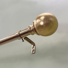 a close up of a gold colored curtain with a metal hook on the top and bottom