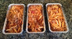 three pans filled with pasta and meat sitting on a counter top next to each other