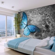 a bedroom with a large blue butterfly painted on the wall next to a bed and window